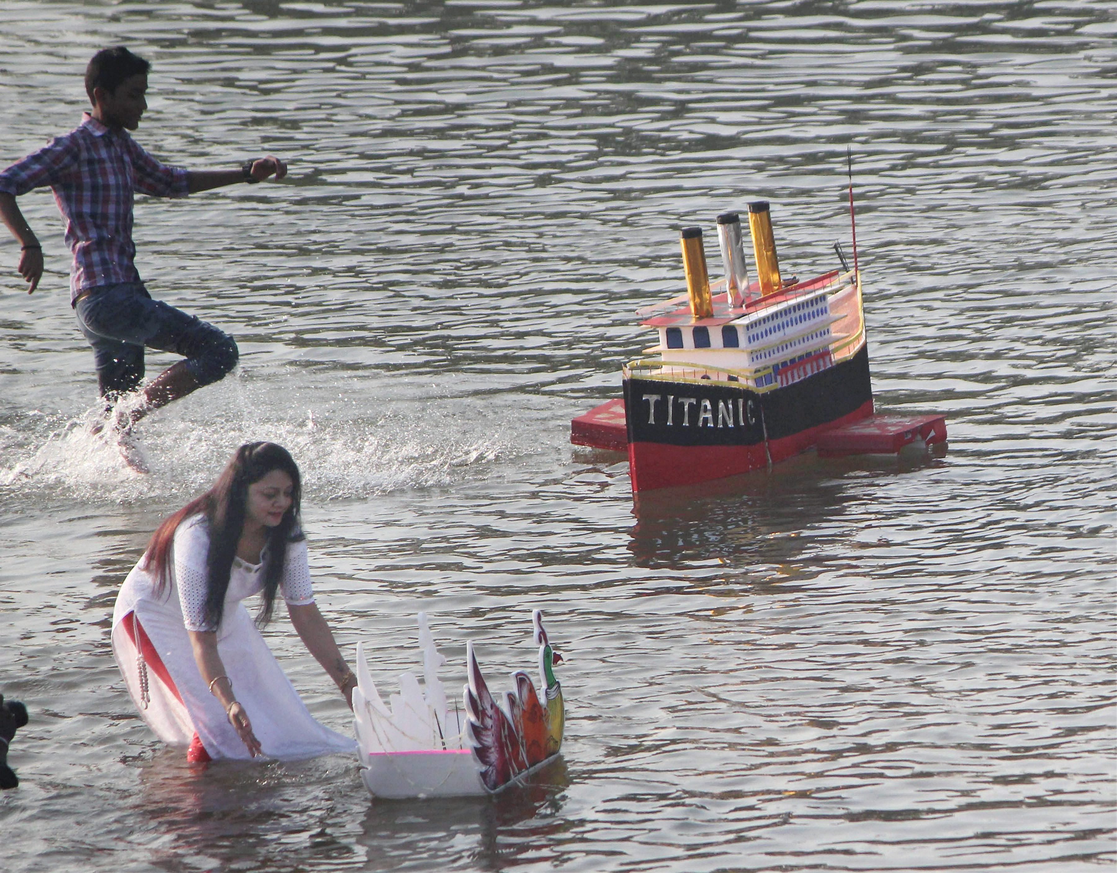 A woman gives her decorative boat a push in Daya river in Bhubaneswar, as part of Karti Purnima celebrations. (Credit: PTI) A woman gives her decorative boat a push in Daya river in Bhubaneswar, as part of Karti Purnima celebrations. (Credit: PTI)