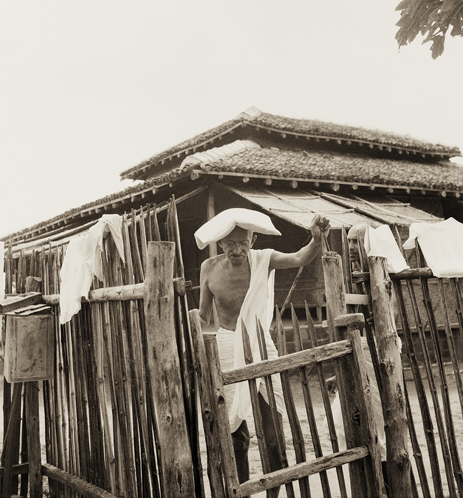 Mahatma Gandhi in front of his hut, carrying a pillow on his head as protection against severe heat, 1940. (Photograph by Kanu Gandhi / © Gita Mehta, heir of Abha and Kanu Gandhi) Mahatma Gandhi in front of his hut, carrying a pillow on his head as protection against severe heat, 1940. (Photograph by Kanu Gandhi / © Gita Mehta, heir of Abha and Kanu Gandhi)