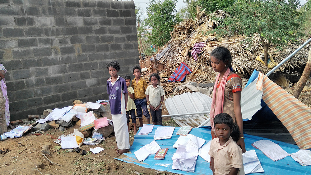 Children of Sankarapuram Irula settlement drying school textbooks that were damaged by the storm Children of Sankarapuram Irula settlement drying school textbooks that were damaged by the storm