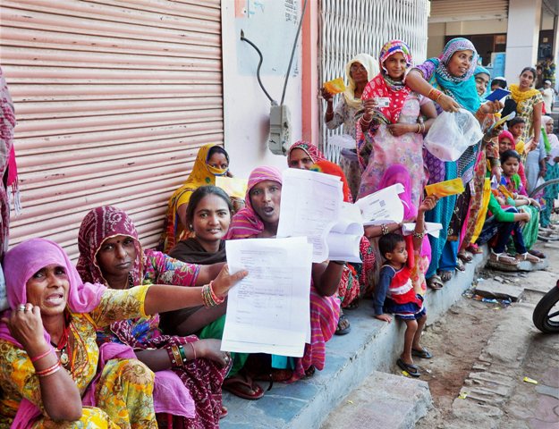 Women hold out the forms they had to fill as they wait outside a Bikaner bank in Rajasthan. Photo: PTI Women hold out the forms they had to fill as they wait outside a Bikaner bank in Rajasthan. Photo: PTI