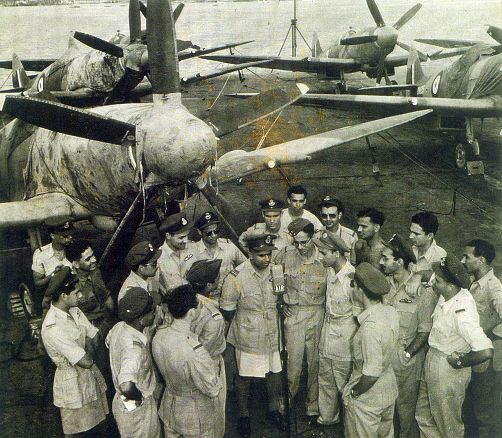 The squadron commanding officer, Squadron Leader Jagdev Chandra (centre, in shorts) talks to his officers aboard HMS Vengeance. Note that the aircraft have their engines, wing roots and guns covered and sealed, for protection against the sea air. Photo Courtesy: Late Wing Commander CHL Digby's family The squadron commanding officer, Squadron Leader Jagdev Chandra (centre, in shorts) talks to his officers aboard HMS Vengeance. Note that the aircraft have their engines, wing roots and guns covered and sealed, for protection against the sea air. Photo Courtesy: Late Wing Commander CHL Digby's family