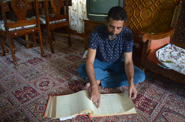 Tariq Ahmad Patloo showing the entries of foreign guests during 1980s from an old log book of his house-boat New Sea Palace. Photo credit: Athar Parvaiz/IndiaSpend.com Tariq Ahmad Patloo showing the entries of foreign guests during 1980s from an old log book of his house-boat New Sea Palace. Photo credit: Athar Parvaiz/IndiaSpend.com
