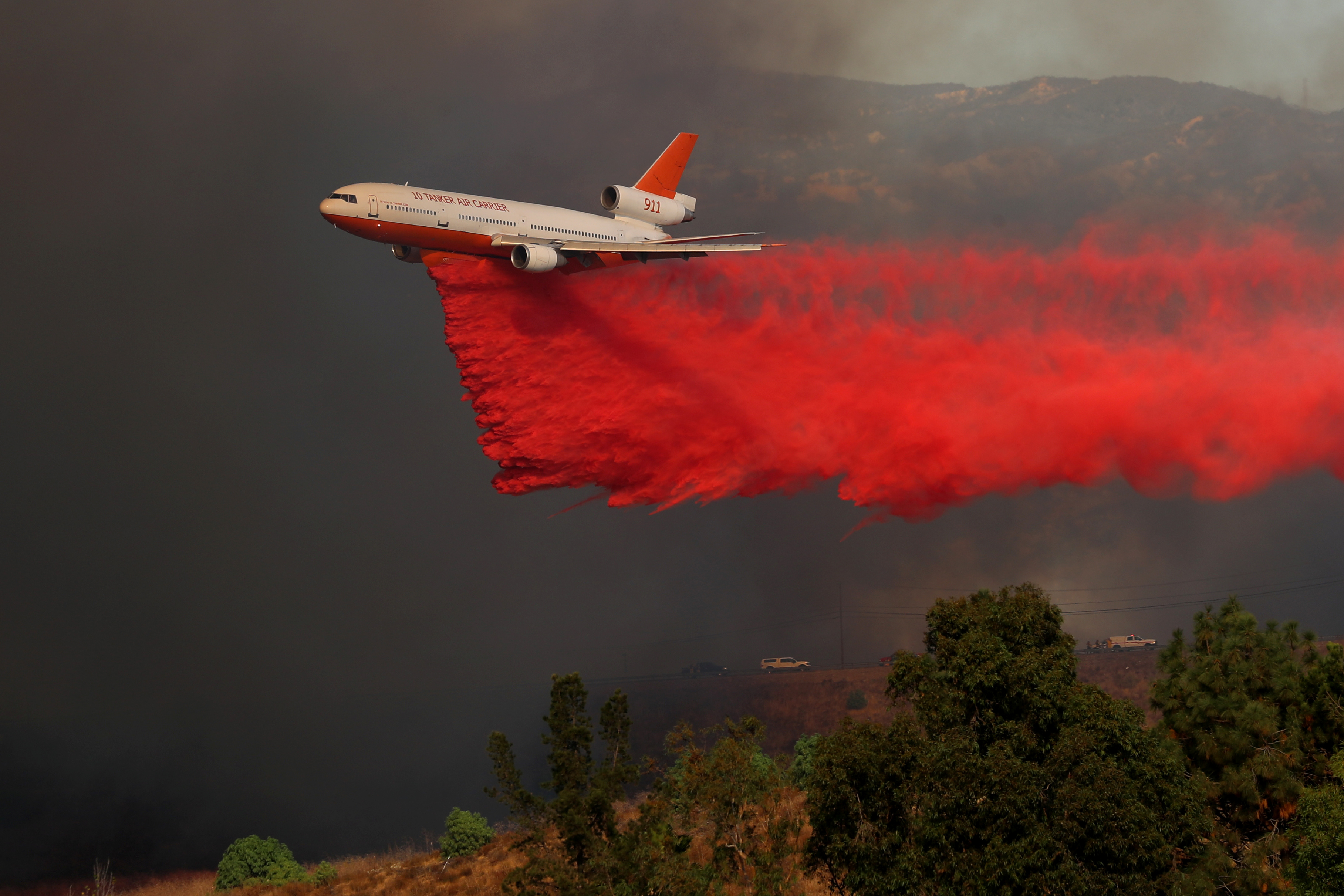 A DC-10 aircraft drops fire retardant on the wildfire. (Photo Credit: Mike Blake/Reuters) A DC-10 aircraft drops fire retardant on the wildfire. (Photo Credit: Mike Blake/Reuters)