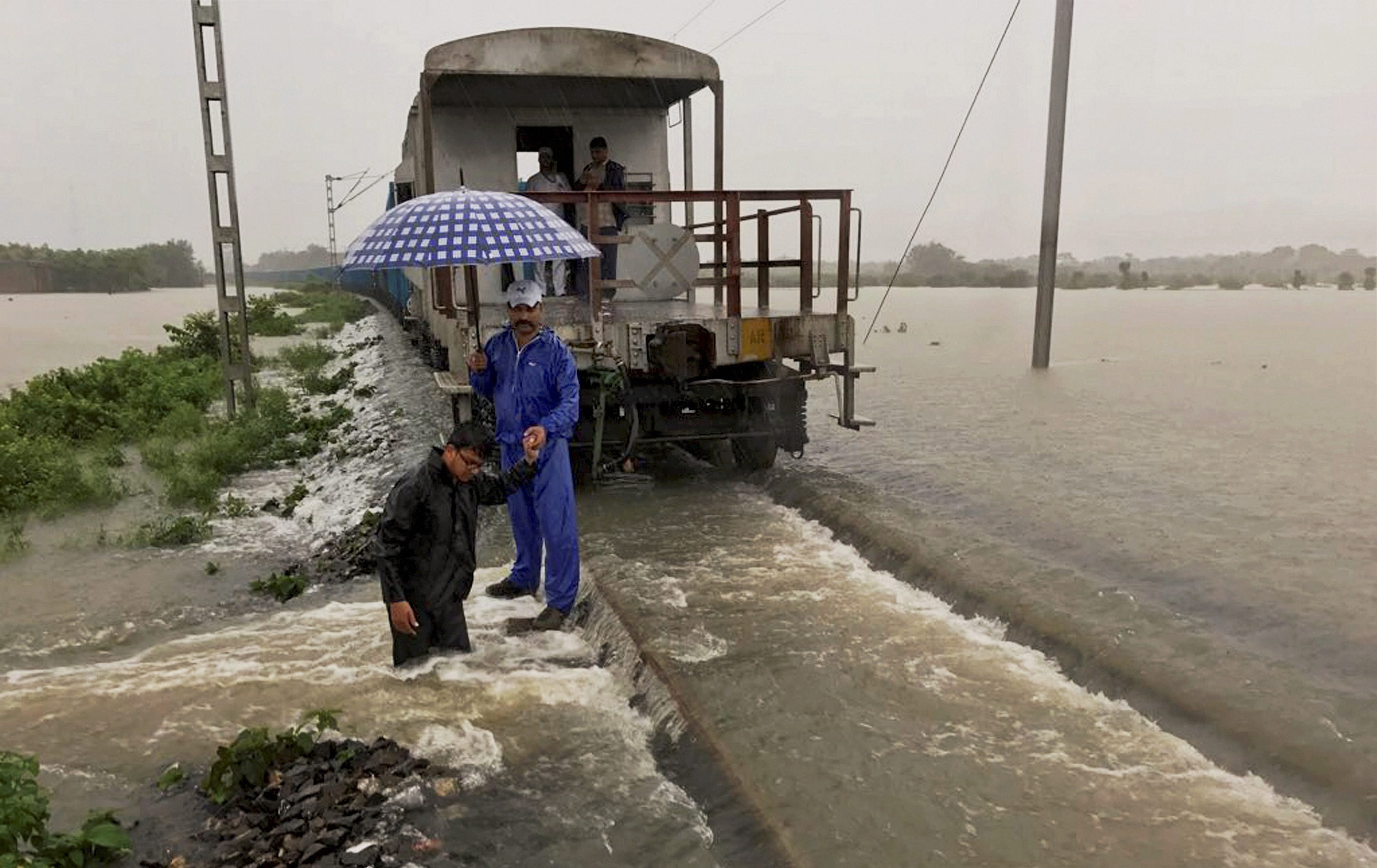A goods train is halted as railway officials inspect a damaged embankment along the Katihar-Guwahati route. (Credit: PTI) A goods train is halted as railway officials inspect a damaged embankment along the Katihar-Guwahati route. (Credit: PTI)