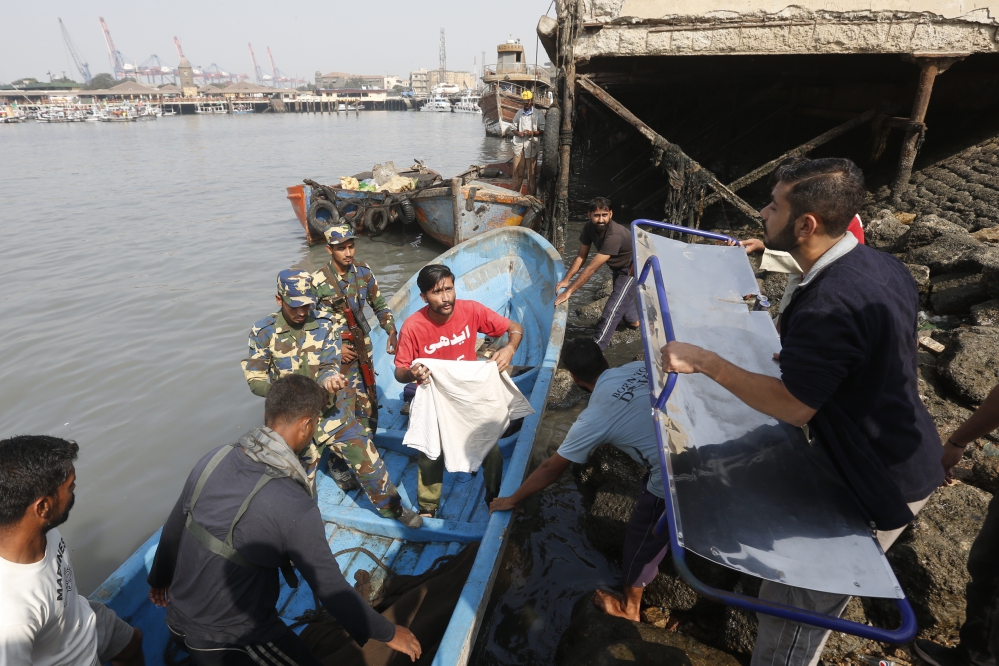 Safdar holds a sheet to cover a body retrieved at the port. (Photo: Akthar Soomro/Reuters) Safdar holds a sheet to cover a body retrieved at the port. (Photo: Akthar Soomro/Reuters)