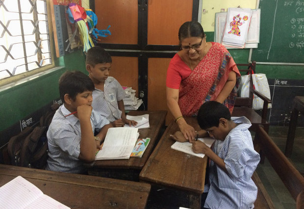 Javed Shaikh with his class teacher, Charulata Patil, at the Jagannath Bhatankar Municipal Corporation School in Parel, Mumbai. When IndiaSpend visited Javed in his school in November, he was writing alphabets in his notebook and would smile when Patil called to him. (Photo credit: Swagata Yadavar) Javed Shaikh with his class teacher, Charulata Patil, at the Jagannath Bhatankar Municipal Corporation School in Parel, Mumbai. When IndiaSpend visited Javed in his school in November, he was writing alphabets in his notebook and would smile when Patil called to him. (Photo credit: Swagata Yadavar)