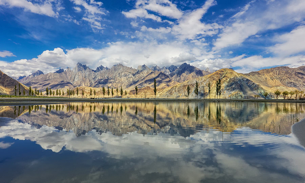 The snow-capped mountains in Skardu are a stunning backdrop to the lake. The snow-capped mountains in Skardu are a stunning backdrop to the lake.