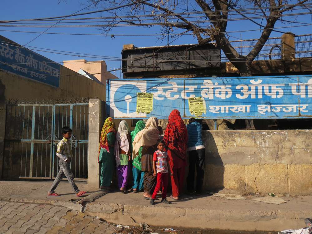 Visitors from a village gather outside the burnt State Bank of Patiala building in Jhajjar. Visitors from a village gather outside the burnt State Bank of Patiala building in Jhajjar.