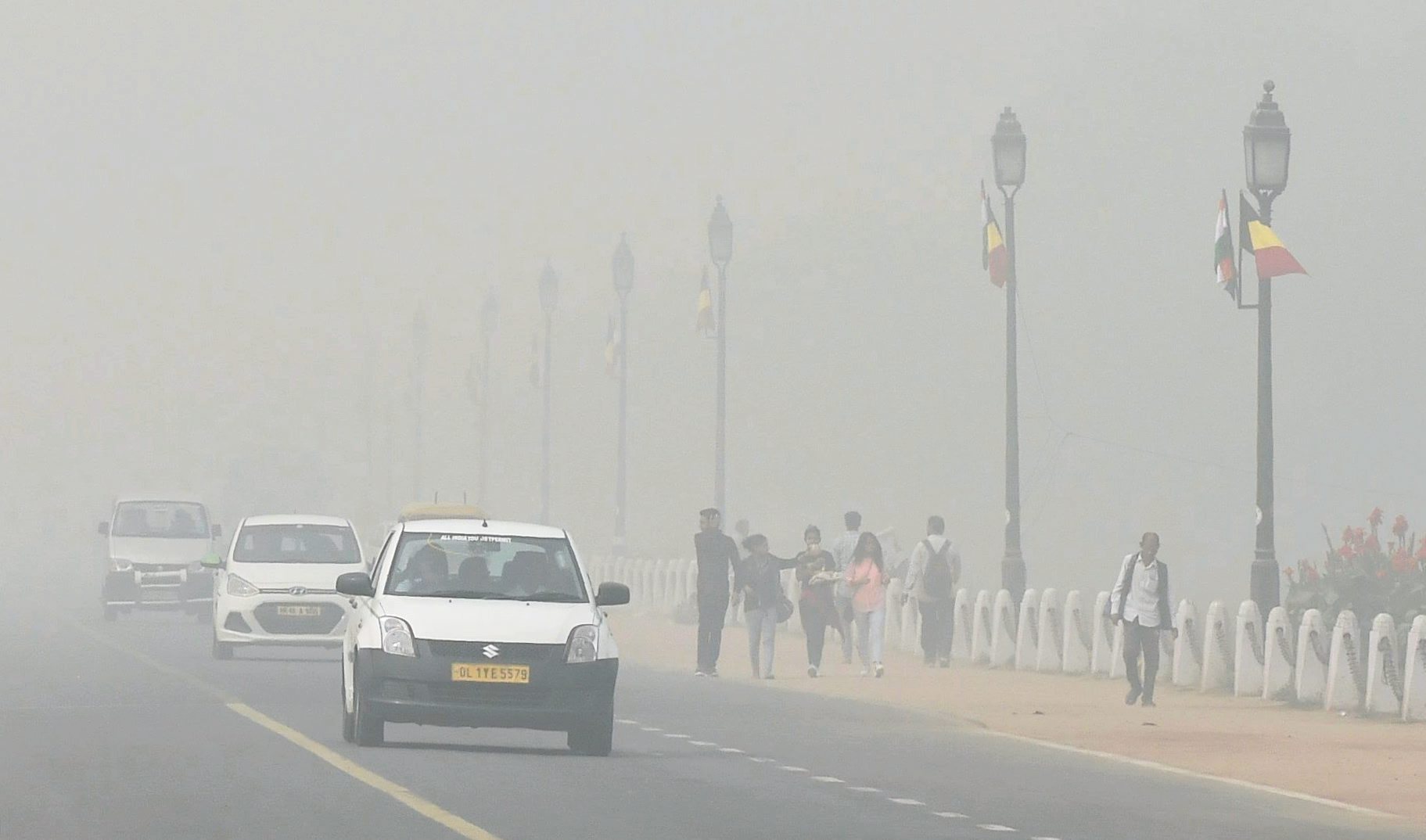 Pedestrians and motorists make their way through thick smog in New Delhi on Tuesday (PTI) Pedestrians and motorists make their way through thick smog in New Delhi on Tuesday (PTI)