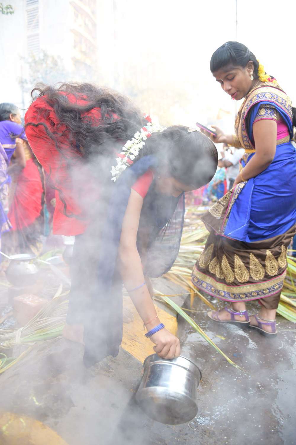 A woman drains out the excess water after cooking the rice. A woman drains out the excess water after cooking the rice.