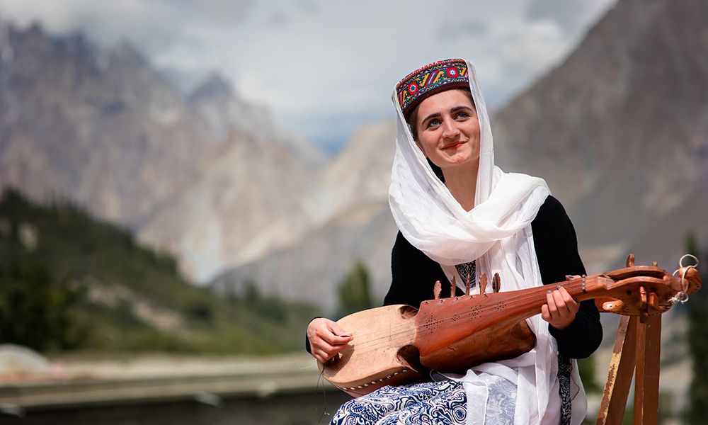 A girl smiles as she plays the traditional instrument, rabab. A girl smiles as she plays the traditional instrument, rabab.