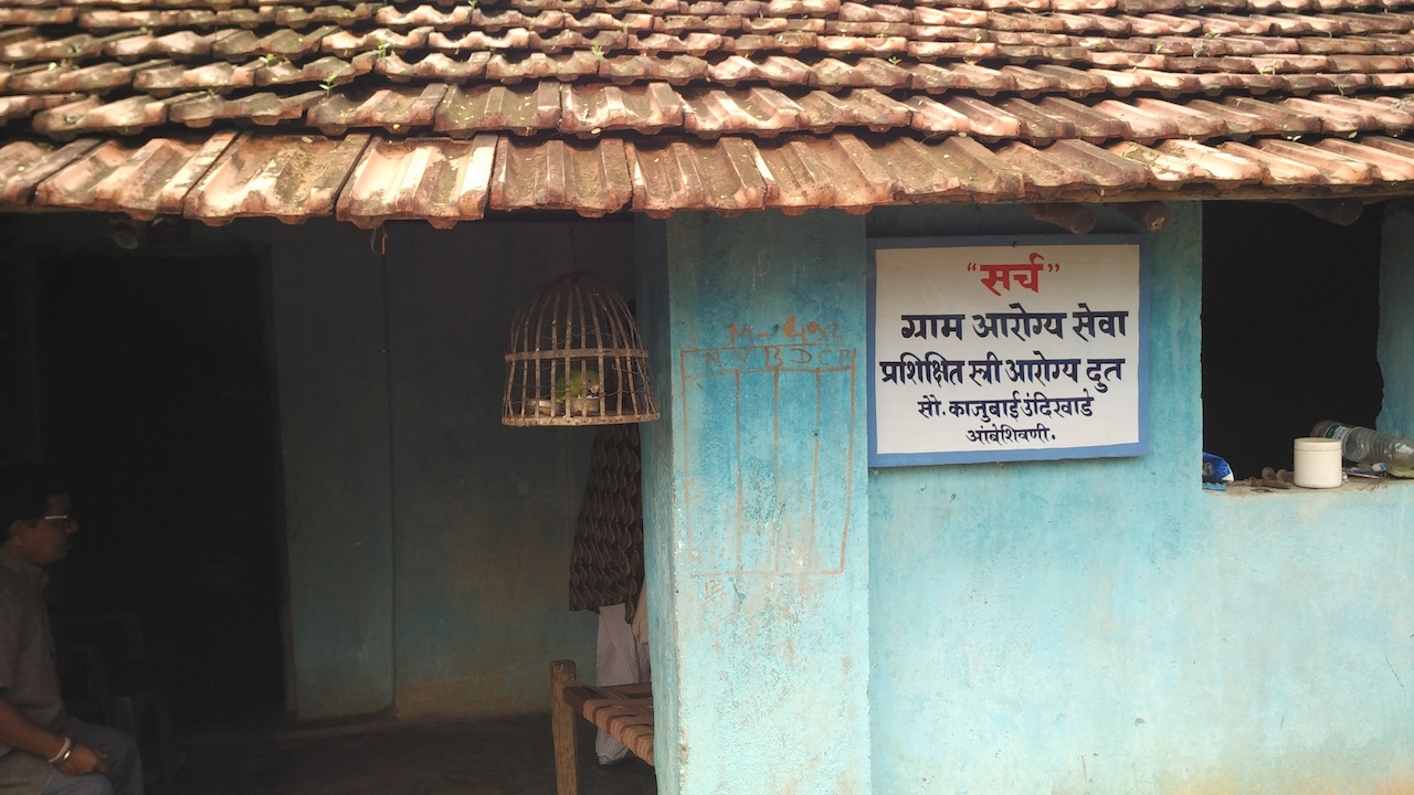 The sign outside Kajubai's house, which reads 'SEARCH: Village health service'. The sign outside Kajubai's house, which reads 'SEARCH: Village health service'.