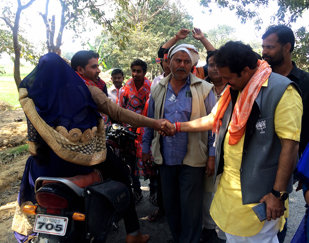 Satish Singh's supporters intercept a passing motorcyclist and make him shake hands with the candidate. Satish Singh's supporters intercept a passing motorcyclist and make him shake hands with the candidate.