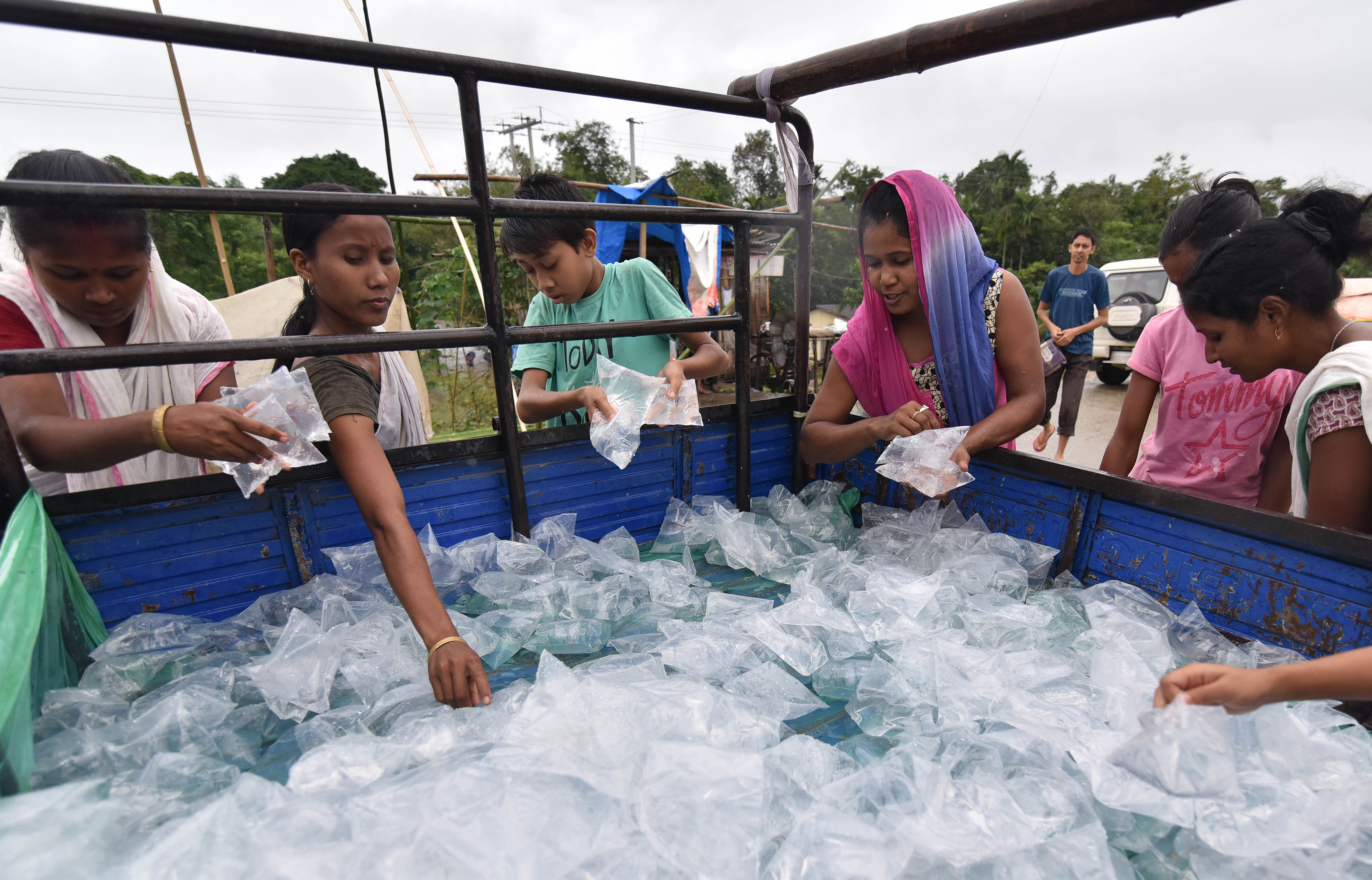 People collect water pouches in flood-affected Lakhimpur district in Assam. Biju Boro/AFP Photo People collect water pouches in flood-affected Lakhimpur district in Assam. Biju Boro/AFP Photo