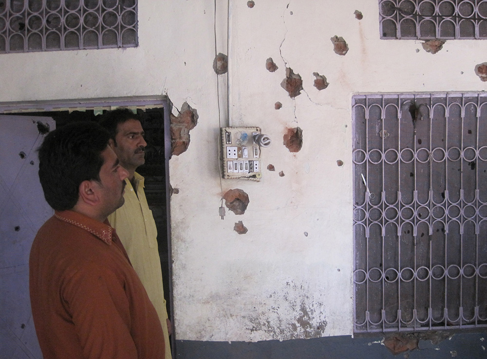 Pakistani villagers pose for a photograph alongside a bullet-riddled wall of their home following mortar shelling by the Indian Border Security Force in Chaprar village along the Sialkot Working Boundary on October 25. Credit: Abid Hussain Mehdi/AFP Pakistani villagers pose for a photograph alongside a bullet-riddled wall of their home following mortar shelling by the Indian Border Security Force in Chaprar village along the Sialkot Working Boundary on October 25. Credit: Abid Hussain Mehdi/AFP
