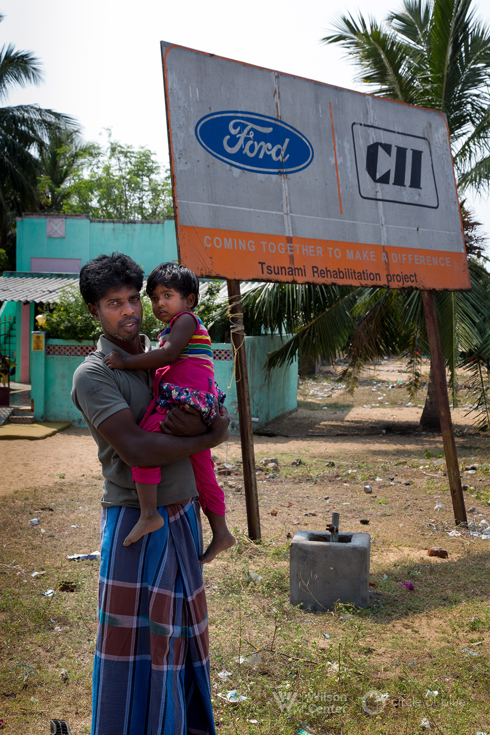 In 2004, the Indian Ocean tsunami struck southern India, killing more than 6,400 people. Two people died and most homes were ruined in Panaiyur Periya Kuppam, the fishing village closest to Vilambur. Ananda Velu, here with his daughter Anushree, was 20-years-old when the tidal wave drowned the village of 2,500 residents. Photograph by, Dhruv Malhotra © Wilson Center/Circle of Blue In 2004, the Indian Ocean tsunami struck southern India, killing more than 6,400 people. Two people died and most homes were ruined in Panaiyur Periya Kuppam, the fishing village closest to Vilambur. Ananda Velu, here with his daughter Anushree, was 20-years-old when the tidal wave drowned the village of 2,500 residents. Photograph by, Dhruv Malhotra © Wilson Center/Circle of Blue