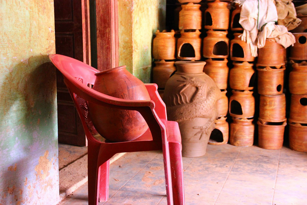 The house is stacked high with terracotta; only the ghatam is seated on a plastic chair. The house is stacked high with terracotta; only the ghatam is seated on a plastic chair.