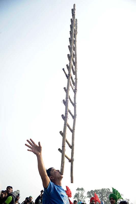 A man balances a ladder on his teeth. A man balances a ladder on his teeth.