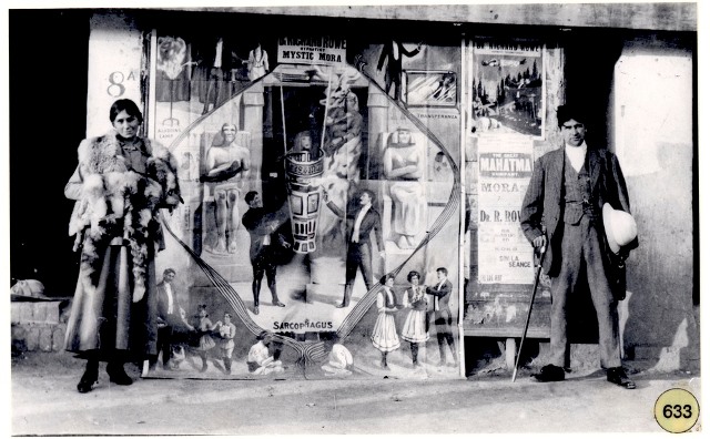 Mystic Mora and Doc Rowe standing in front of posters advertising their performance at the Garrison Theatre, Peshawar (1917). Mystic Mora and Doc Rowe standing in front of posters advertising their performance at the Garrison Theatre, Peshawar (1917).