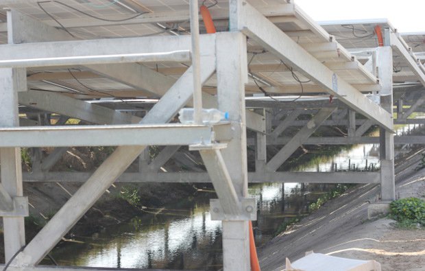 The panels placed at at optimum angle over canal water. When they are cooled from below, their efficiency increases and enhances output by 2.5-5%. Image Credit: Mukta Patil / IndiaSpend The panels placed at at optimum angle over canal water. When they are cooled from below, their efficiency increases and enhances output by 2.5-5%. Image Credit: Mukta Patil / IndiaSpend