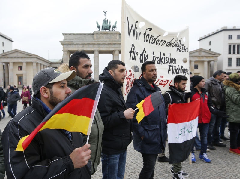 People protest against the deportation of Iraqi refugees from Germany at the Brandenburg Gate in Berlin, in February. The banner should read: We are demanding right to stay for Iraqi refugees. Photo credit: Fabrizio Bensch/Reuters. People protest against the deportation of Iraqi refugees from Germany at the Brandenburg Gate in Berlin, in February. The banner should read: We are demanding right to stay for Iraqi refugees. Photo credit: Fabrizio Bensch/Reuters.