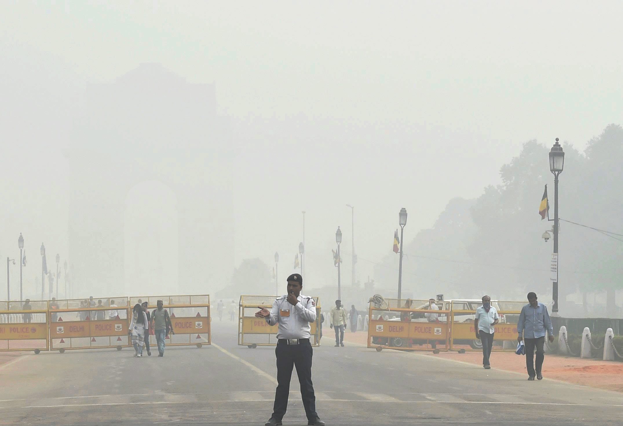 A traffic policeman on duty near India Gate, which was enveloped in a thick cloud of smog, on Tuesday (PTI) A traffic policeman on duty near India Gate, which was enveloped in a thick cloud of smog, on Tuesday (PTI)