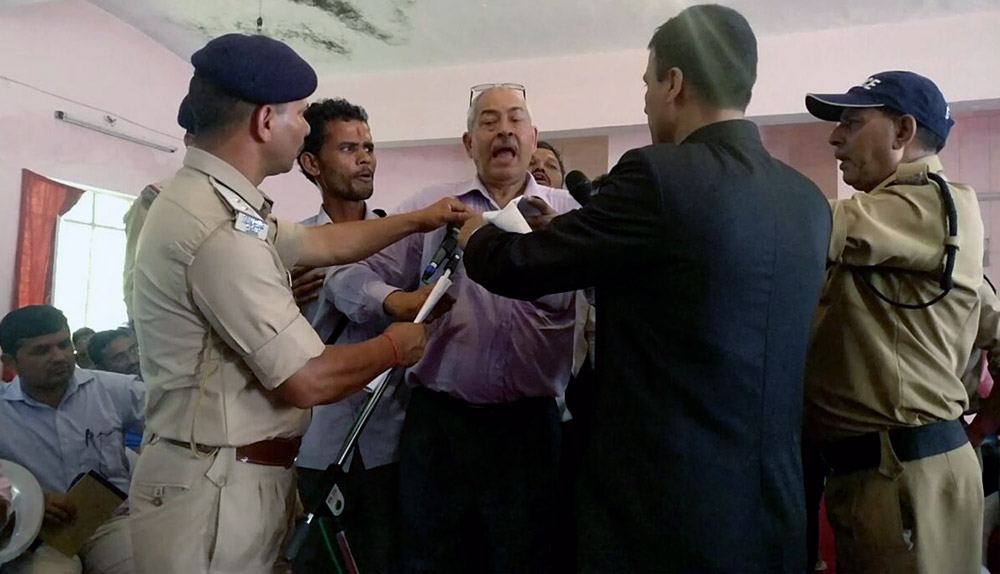 Attendants protest the presence of policemen and leaders of the ruling BJP at the hearing venue. Photo credit: Hridayesh Joshi Attendants protest the presence of policemen and leaders of the ruling BJP at the hearing venue. Photo credit: Hridayesh Joshi