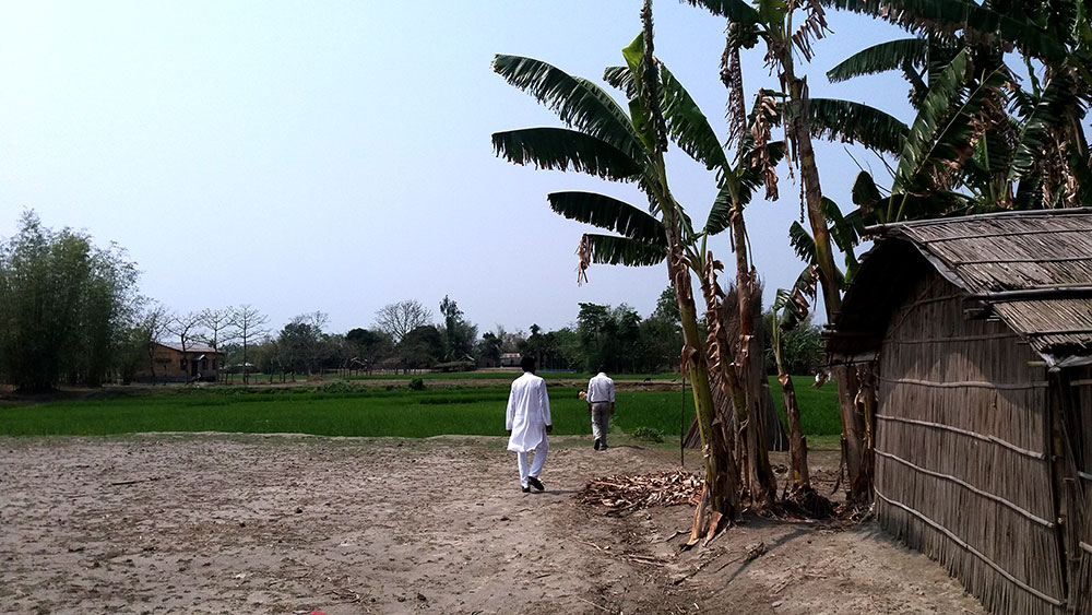 Workers of the All India United Democratic Front walk across a field in Fulkakata. Workers of the All India United Democratic Front walk across a field in Fulkakata.
