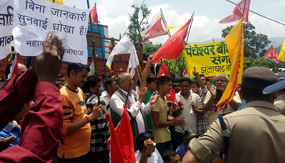 'This public hearing is fraud' reads a banner as protestors gather outside the hearing venue. Photo credit: Rohit Joshi 'This public hearing is fraud' reads a banner as protestors gather outside the hearing venue. Photo credit: Rohit Joshi