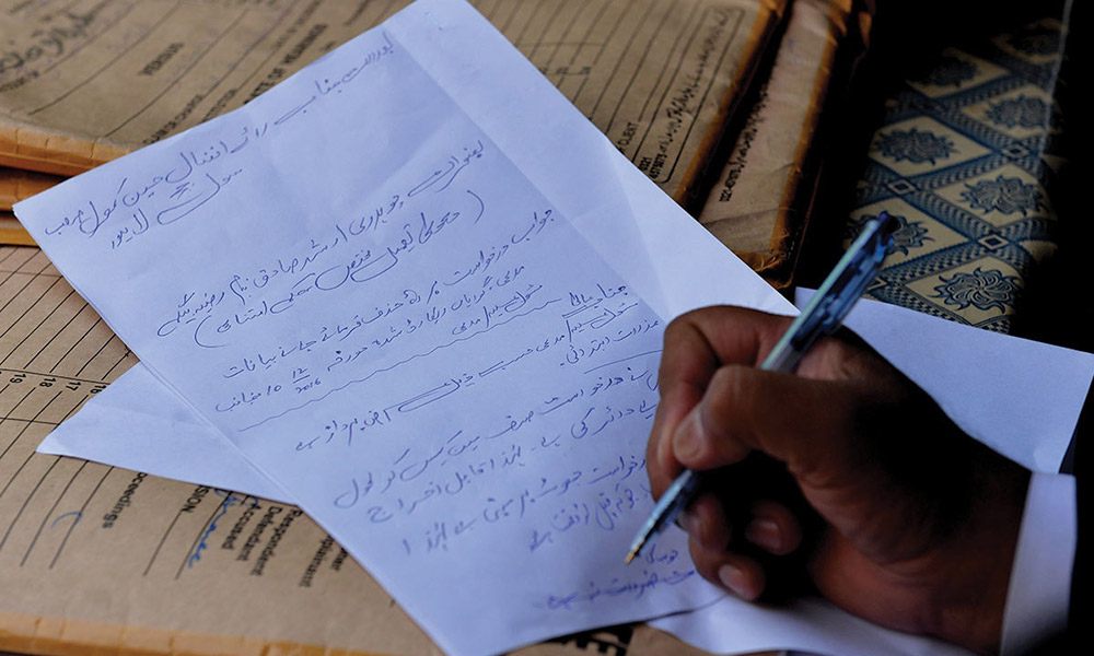 A lawyer writes an application at the Lahore High Court. Photo credit: Murtaza Ali/White Star A lawyer writes an application at the Lahore High Court. Photo credit: Murtaza Ali/White Star