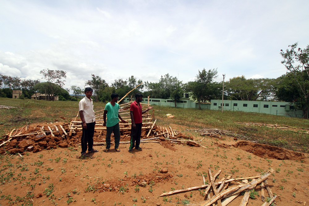 Residents at the eviction site. The wall of the GRG Memorial Tribal School is right alongside it. (Photo credit: Sibi Arasu). Residents at the eviction site. The wall of the GRG Memorial Tribal School is right alongside it. (Photo credit: Sibi Arasu).