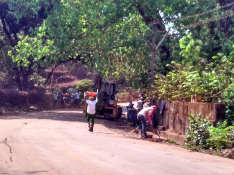 Employees of mining companies clear the debris near the road after villagers protested. (Photo credit: Pamela D'Mello). Employees of mining companies clear the debris near the road after villagers protested. (Photo credit: Pamela D'Mello).
