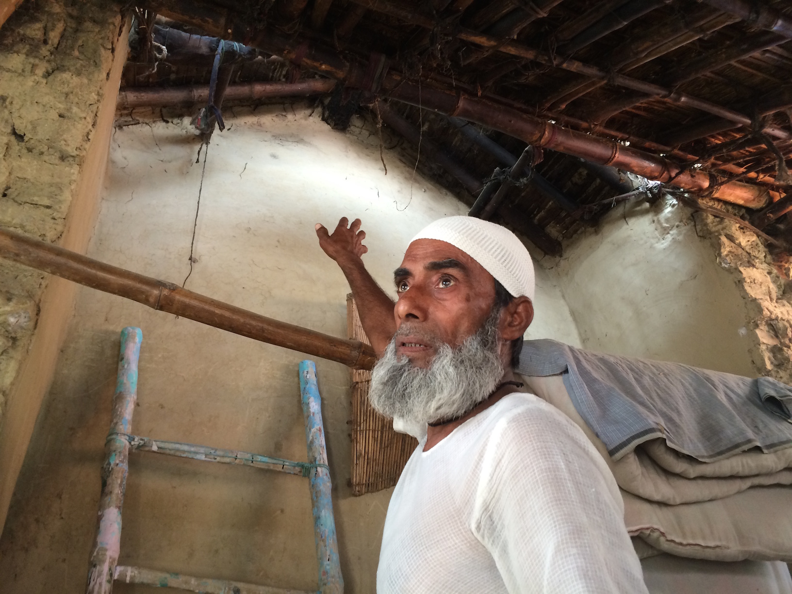 Mohammad Safi shows the charred logs of wood on the roof of his house. Mohammad Safi shows the charred logs of wood on the roof of his house.