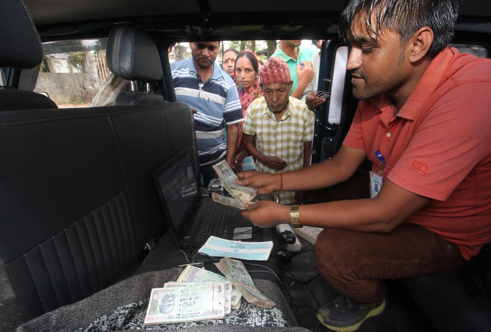 Long queue for money at Simulbarie tea estate as a mobile cash van arrives. Long queue for money at Simulbarie tea estate as a mobile cash van arrives.