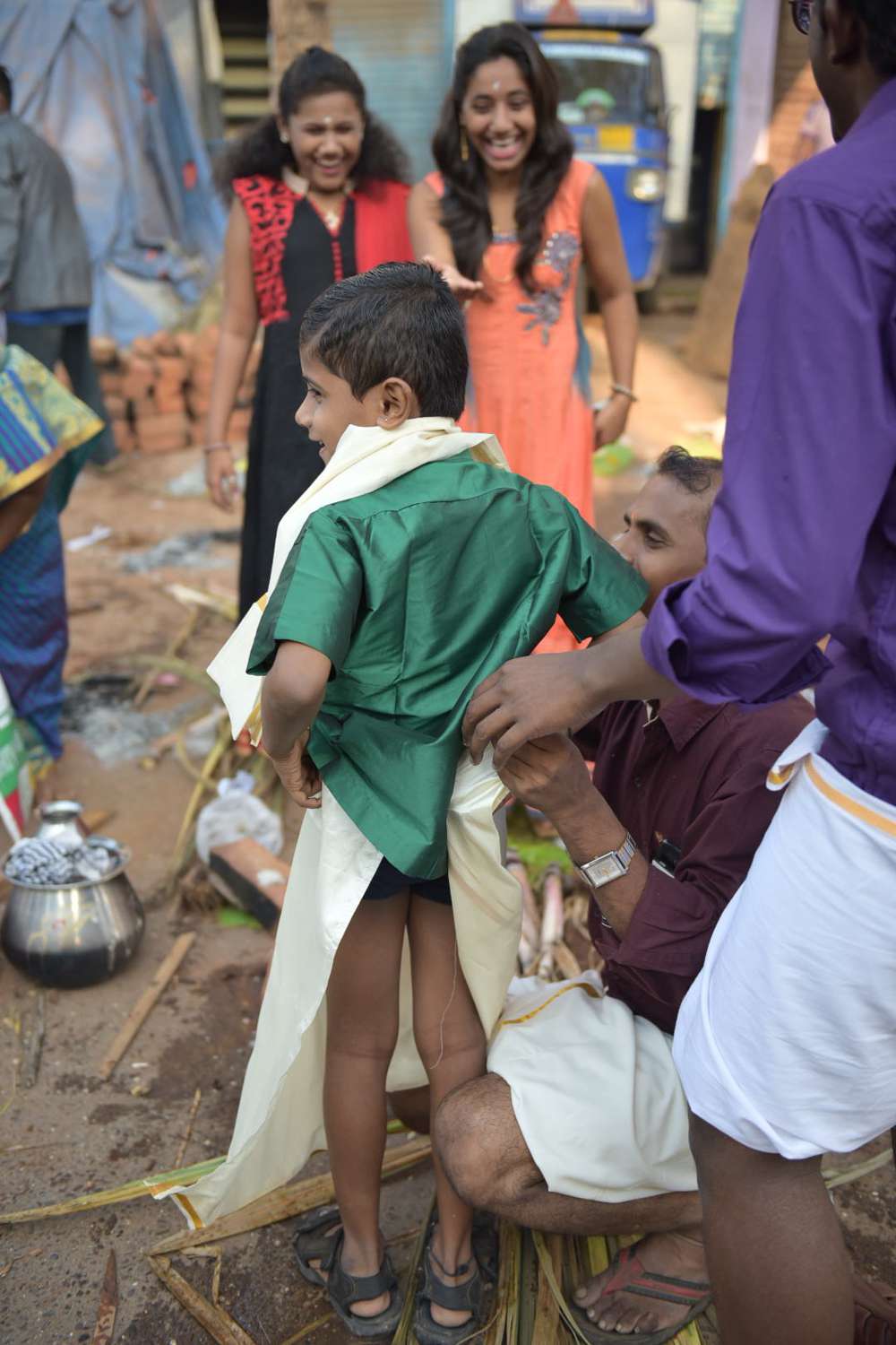 A boy struggles to keep his veshti on. A boy struggles to keep his veshti on.