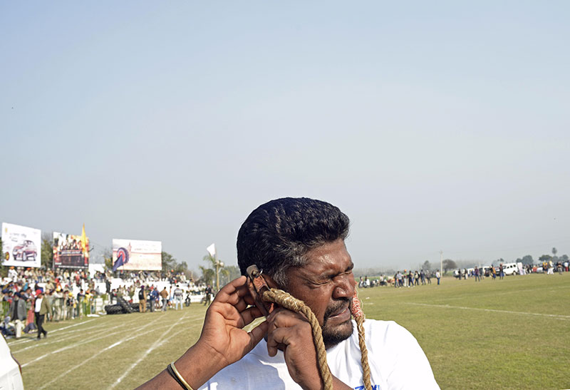 A participant prepares to pull a car with his ears. A participant prepares to pull a car with his ears.