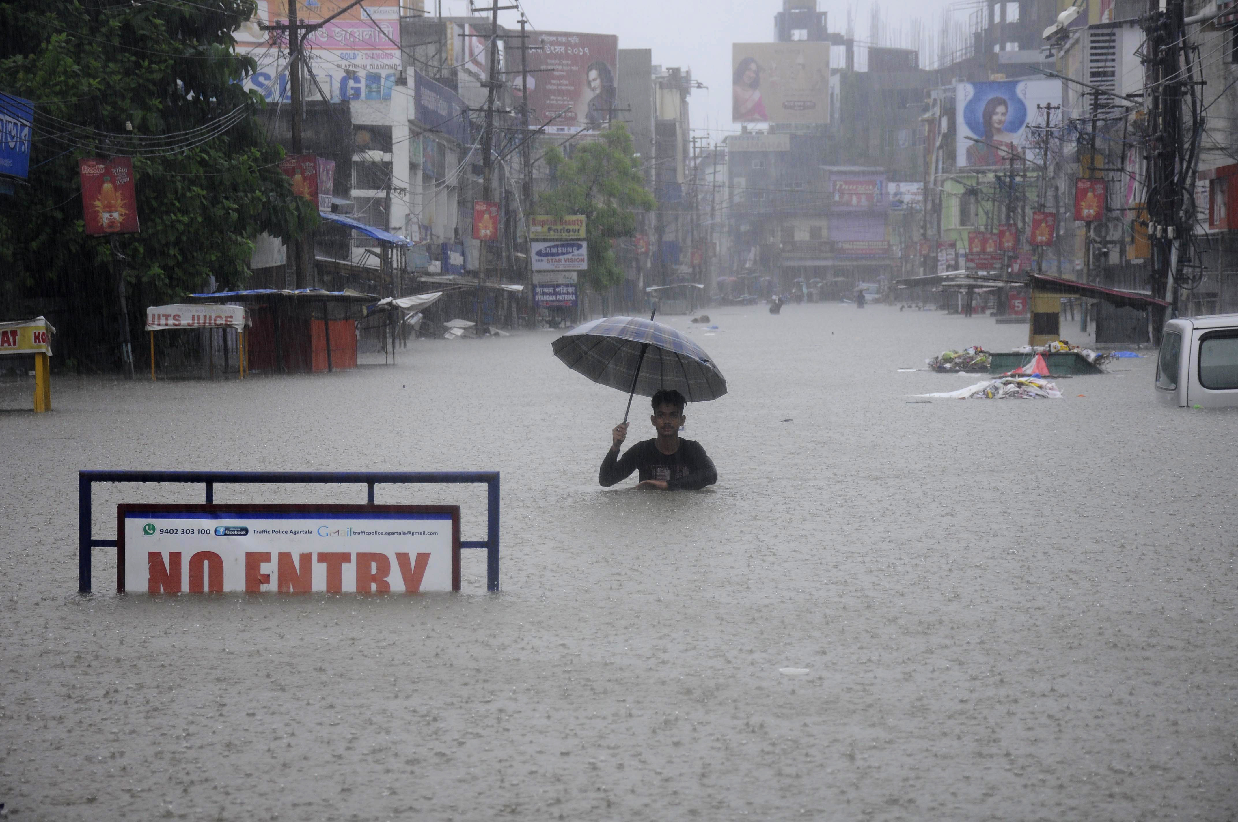 A man wading through flooded street in Tripura's capital Agartala. Arindam Dey/AFP Photo. A man wading through flooded street in Tripura's capital Agartala. Arindam Dey/AFP Photo.