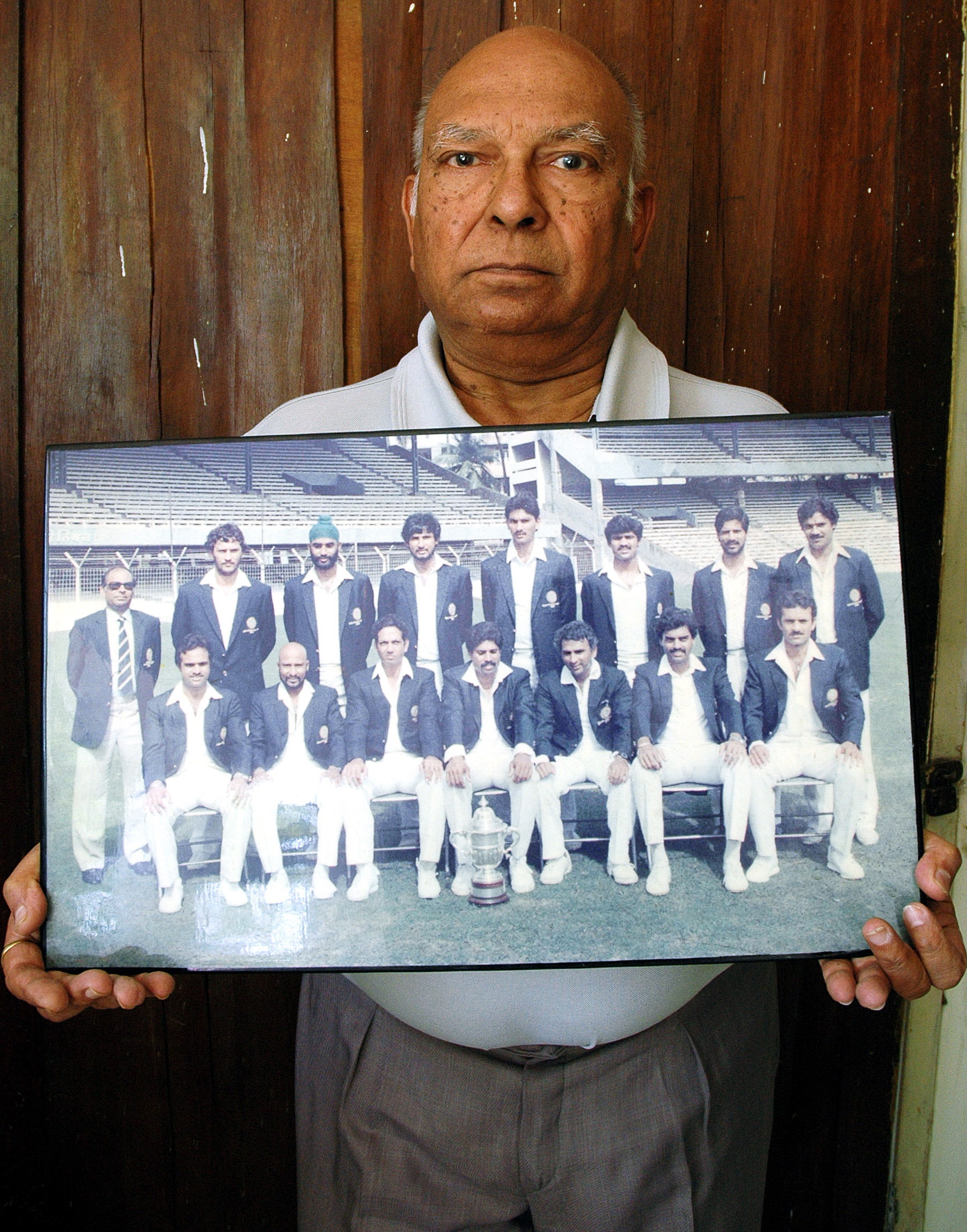 Manager of the team Man Singh holding the group photo that was shot in Mumbai / AFP Manager of the team Man Singh holding the group photo that was shot in Mumbai / AFP