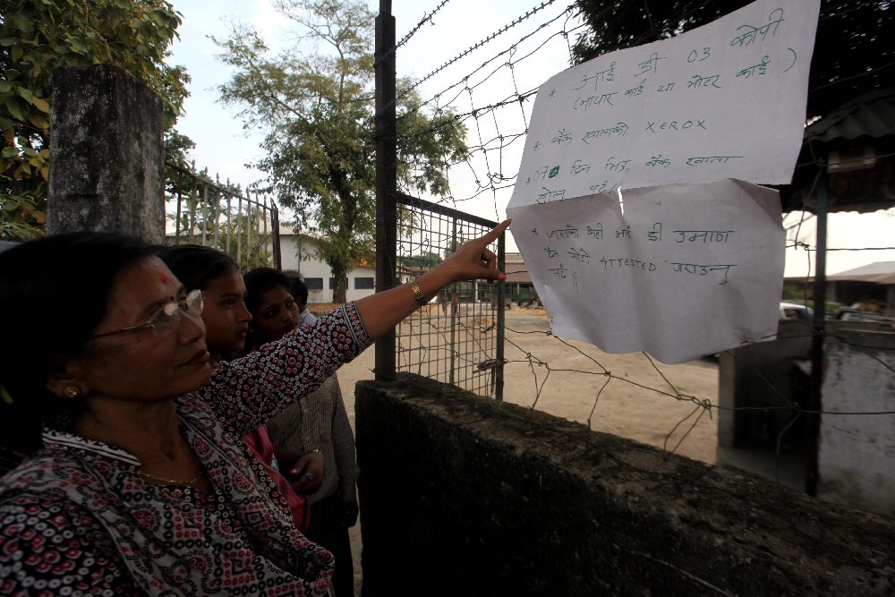 Tea garden staff look at the guidelines for bank enrolment for their next payment of wages. Tea garden staff look at the guidelines for bank enrolment for their next payment of wages.