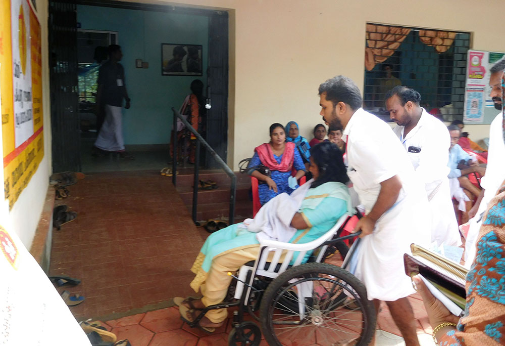 Volunteers carry patients on wheelchair at the Community Health Centre in Koorachundu. Photo TA Ameerudheen Volunteers carry patients on wheelchair at the Community Health Centre in Koorachundu. Photo TA Ameerudheen