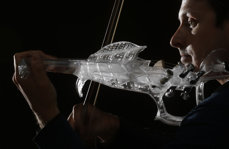 French engineer and professional violinist Laurent Bernadac plays a 3D printed violin made of transparent resin. Image Credits: Christian Hartmann/Reuters French engineer and professional violinist Laurent Bernadac plays a 3D printed violin made of transparent resin. Image Credits: Christian Hartmann/Reuters