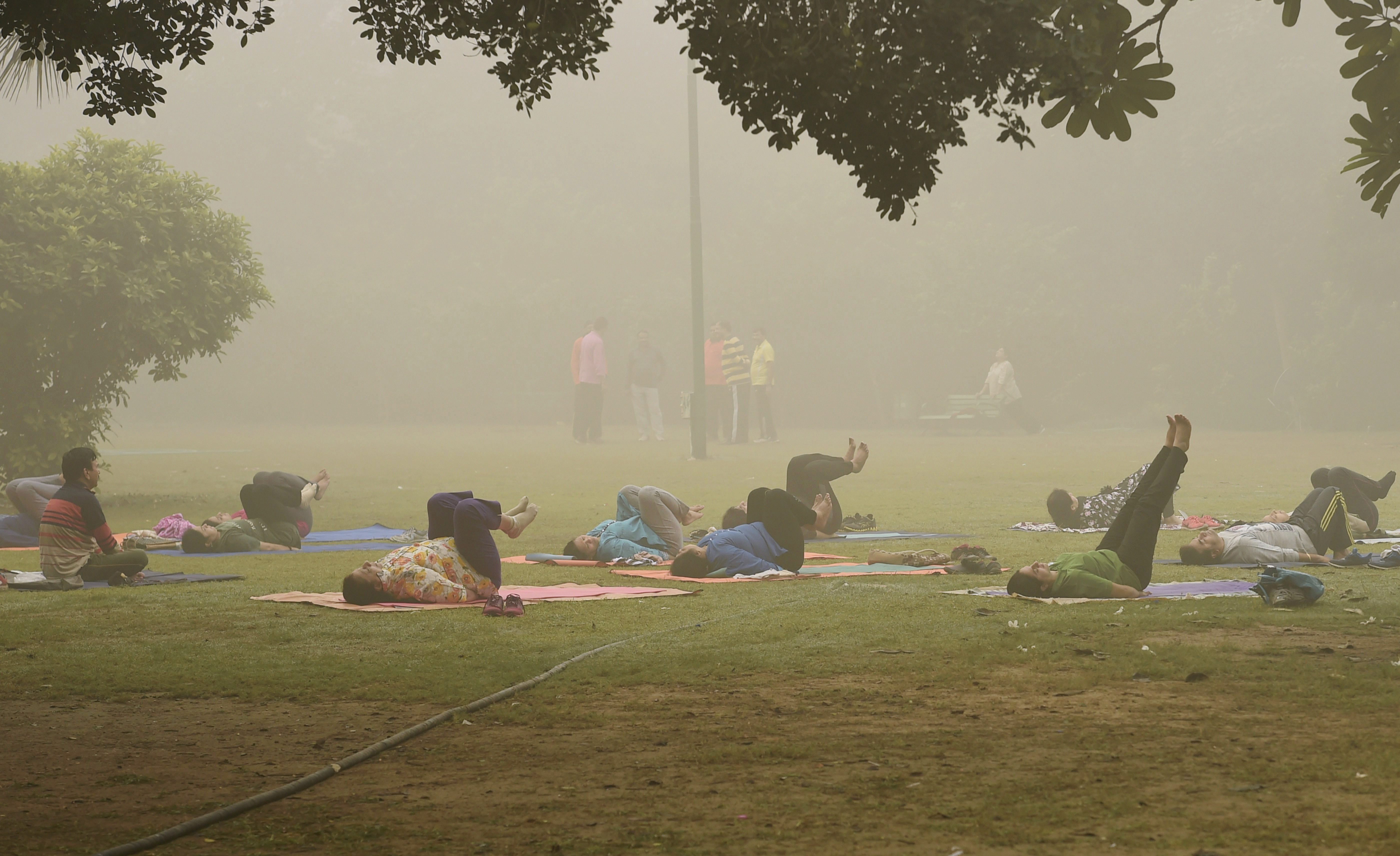 People practice yoga despite the smog at Lodhi Gardens in New Delhi (PTI) People practice yoga despite the smog at Lodhi Gardens in New Delhi (PTI)