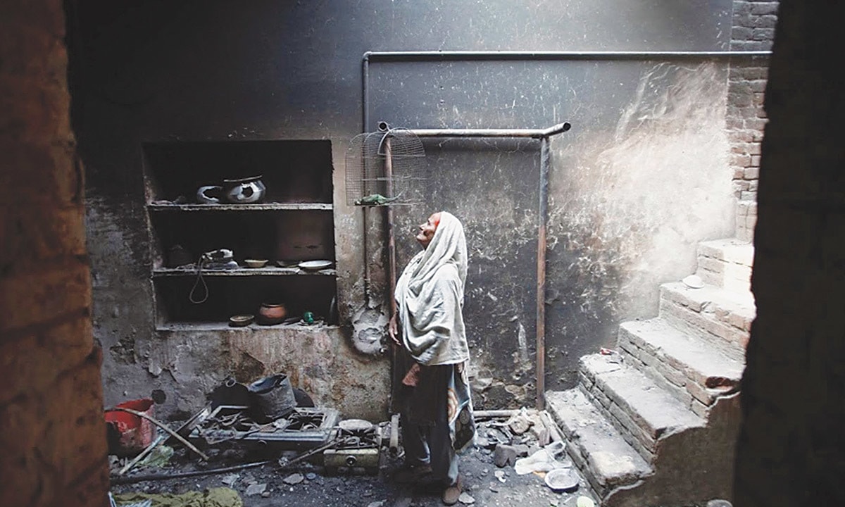 An elderly woman looks at her pet bird, which died during the mob attack on Joseph Colony in March 2013 | Reuters An elderly woman looks at her pet bird, which died during the mob attack on Joseph Colony in March 2013 | Reuters