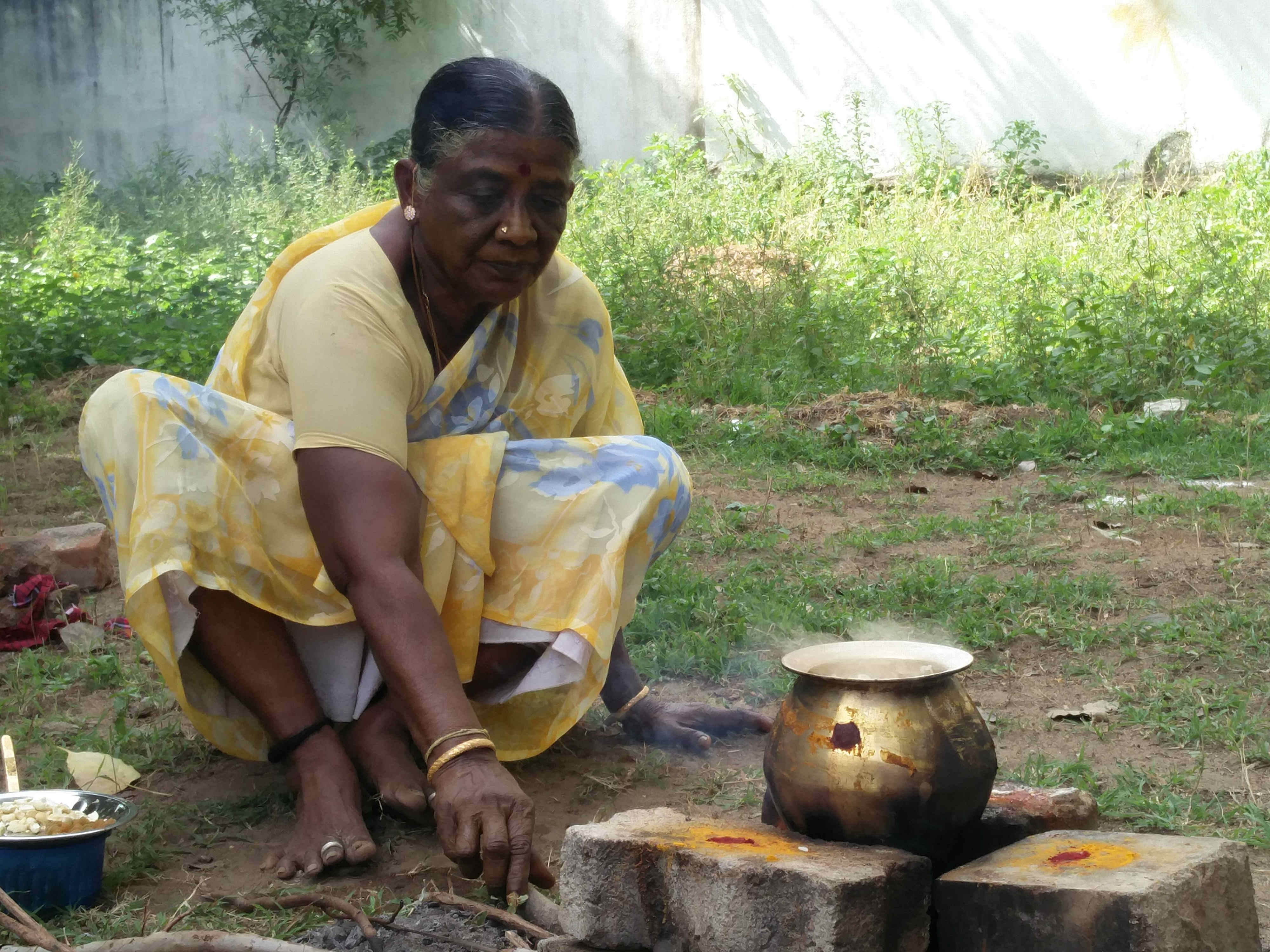 A lady preparing Pongal, a popular rice dish. A lady preparing Pongal, a popular rice dish.