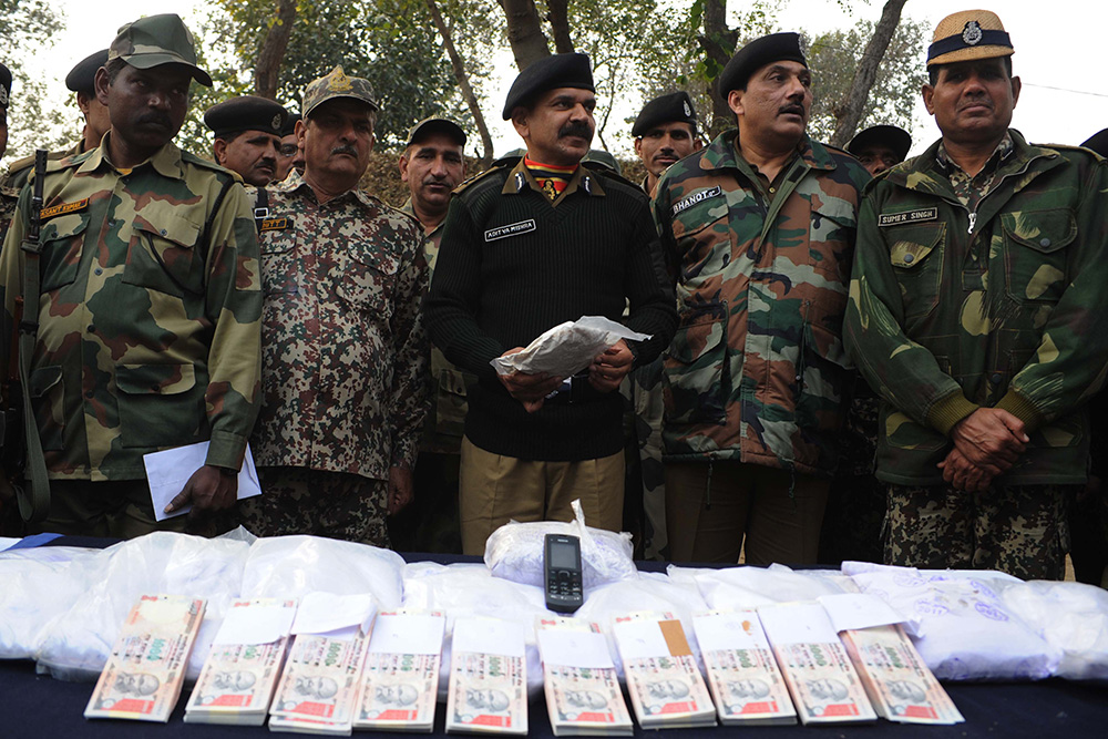 Indian Border Security Force Inspector General Aditya Mishra and Deputy Inspector General Sanjeev Bhanot pose with 17 packets of confiscated heroin, and fake Indian Rupees during a press conference, held near the India-Pakistan Border at Bharopal, on January 18, 2012. Credit: Narinder Nanu/AFP Indian Border Security Force Inspector General Aditya Mishra and Deputy Inspector General Sanjeev Bhanot pose with 17 packets of confiscated heroin, and fake Indian Rupees during a press conference, held near the India-Pakistan Border at Bharopal, on January 18, 2012. Credit: Narinder Nanu/AFP