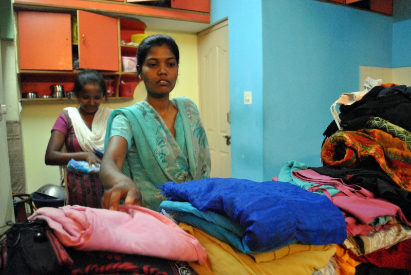 Saniaro Barjo and Sushita Kumar fold laundry at their Bengaluru hostel after work. Photo credit: Rohini Mohan. Saniaro Barjo and Sushita Kumar fold laundry at their Bengaluru hostel after work. Photo credit: Rohini Mohan.