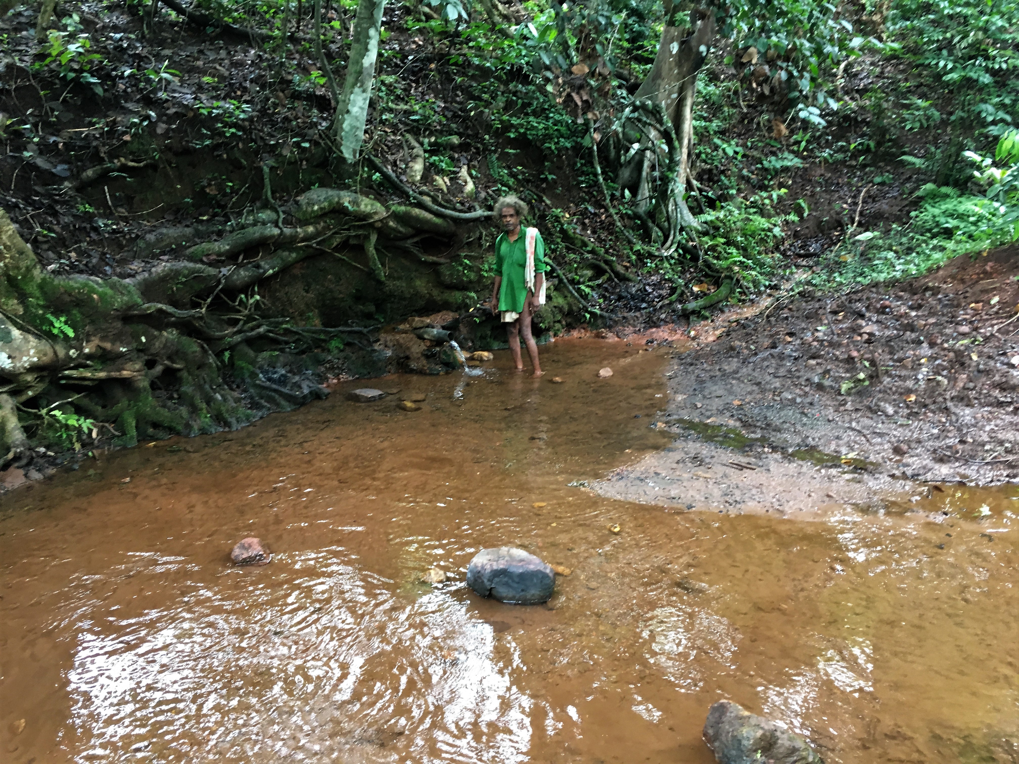 A villager shows the pipe from which they source water. A villager shows the pipe from which they source water.