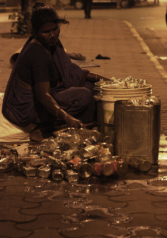 At midnight, some homeless families in King's Circle, Matunga give the final touches to already cleaned glass bottles, readying them for sale. Others in the same family make small temple hangings to be sold early in the morning. At midnight, some homeless families in King's Circle, Matunga give the final touches to already cleaned glass bottles, readying them for sale. Others in the same family make small temple hangings to be sold early in the morning.