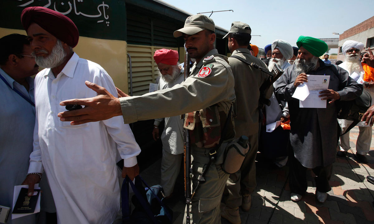 Paramilitary soldiers escort Indian Sikh pilgrims as they arrive at the Wagah border in Pakistan. (Credit: Reuters) Paramilitary soldiers escort Indian Sikh pilgrims as they arrive at the Wagah border in Pakistan. (Credit: Reuters)