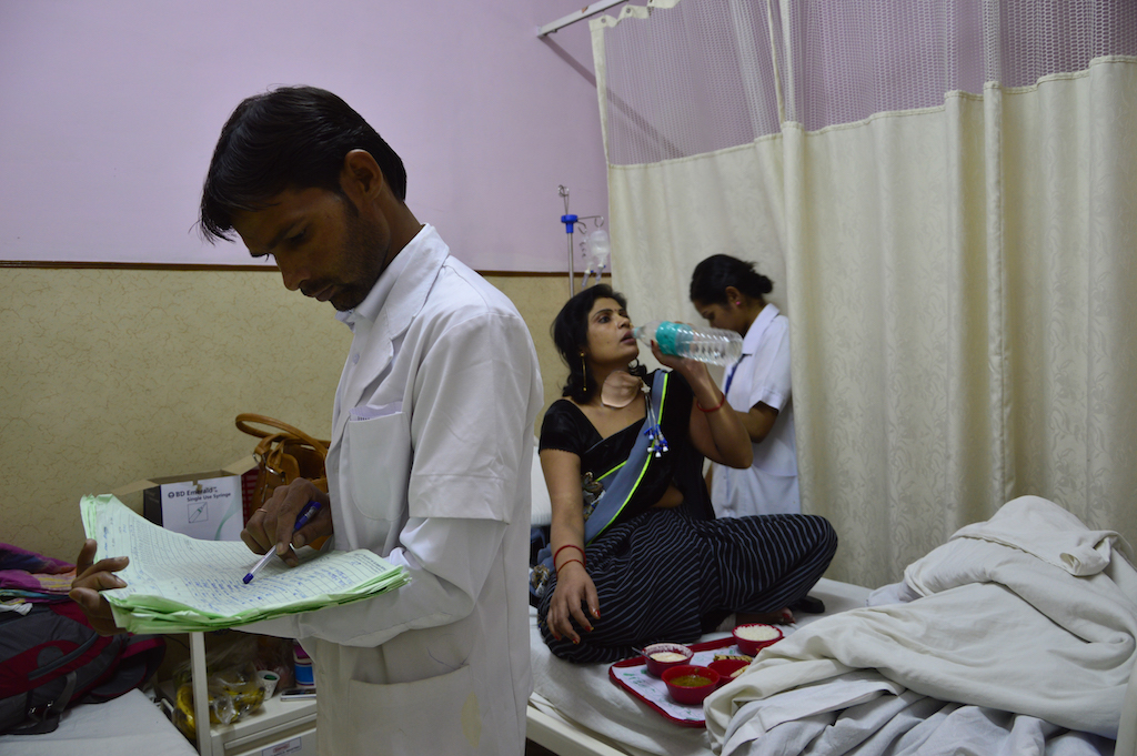 Male nurse on duty, checks the list of medicines to be taken by patient post lunch. Male nurse on duty, checks the list of medicines to be taken by patient post lunch.